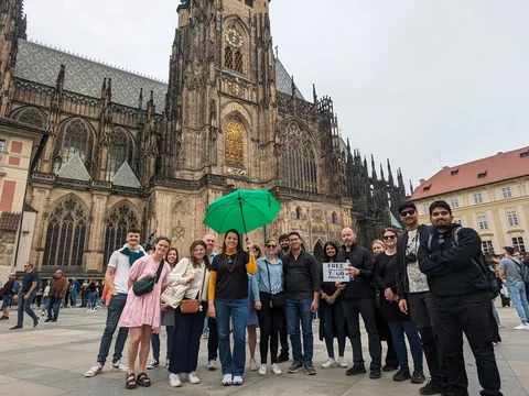 Guests with a green tour umbrella outside St Vitus Cathedral at Prague Castle.